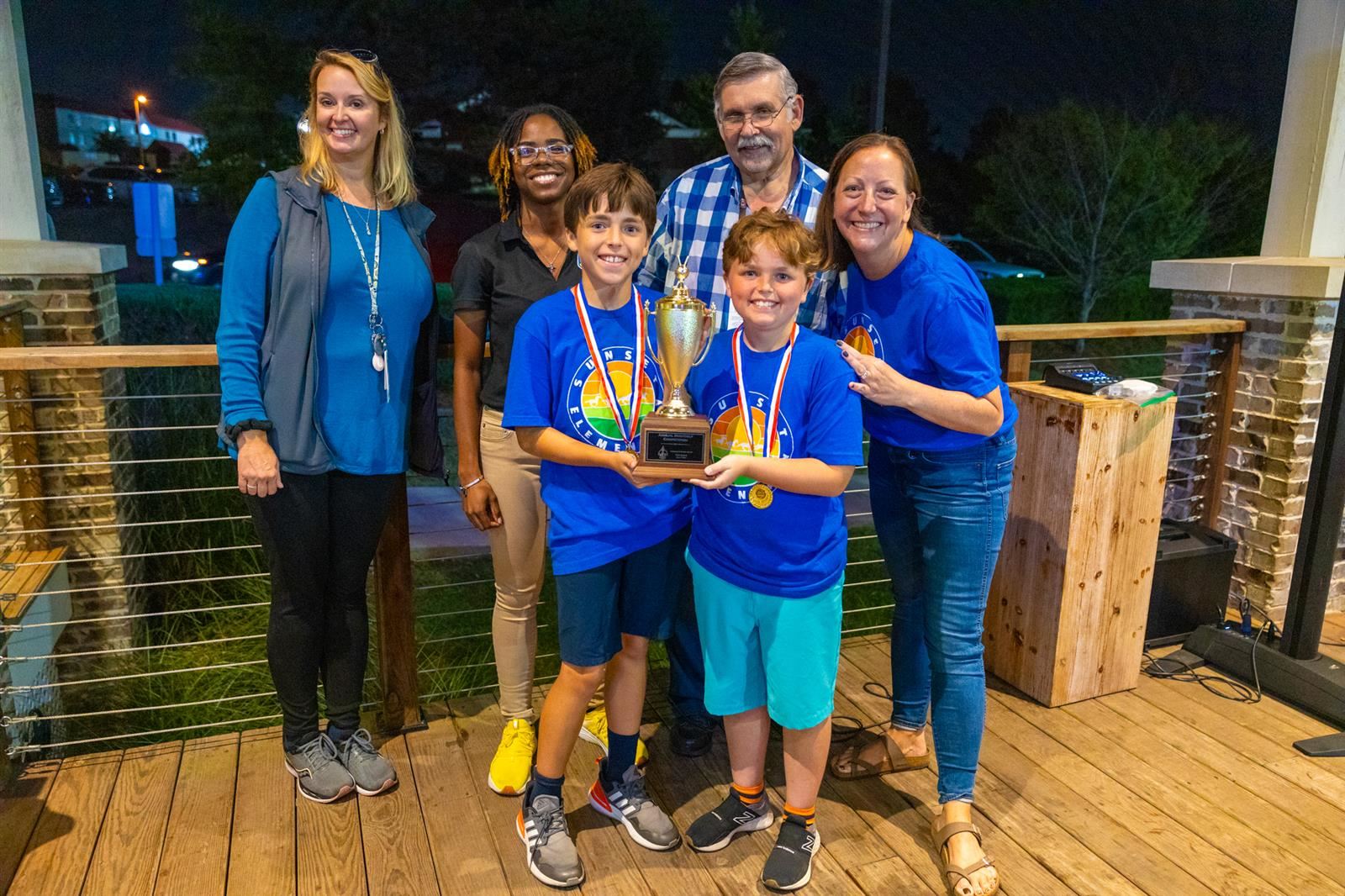 principal, students and staff with trophy at mini golf